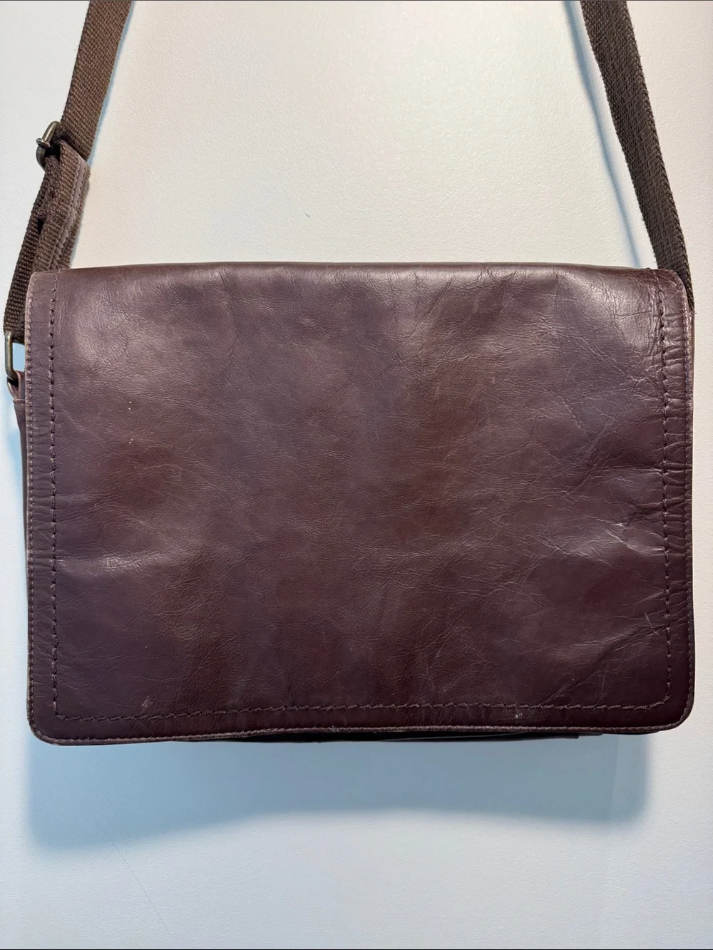 Wilson’s Leather chocolate brown messenger bag with webbed adjustable strap.